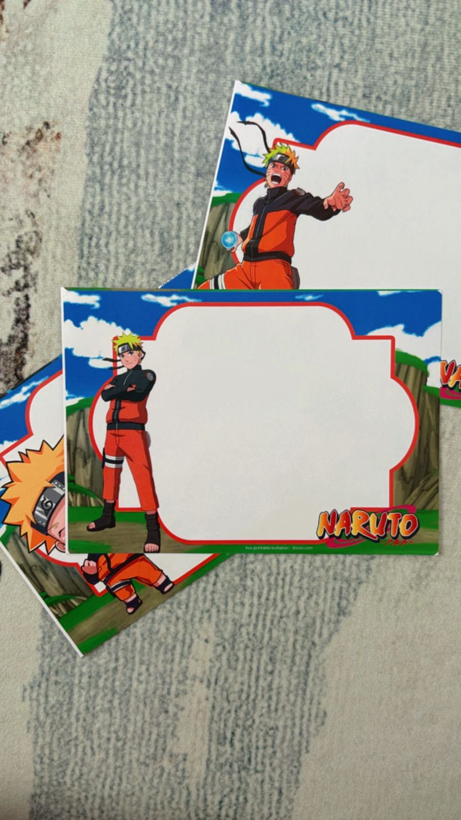 Kid holding Naruto birthday invitation surrounded by ninja props like headbands, kunai toys, and orange decor