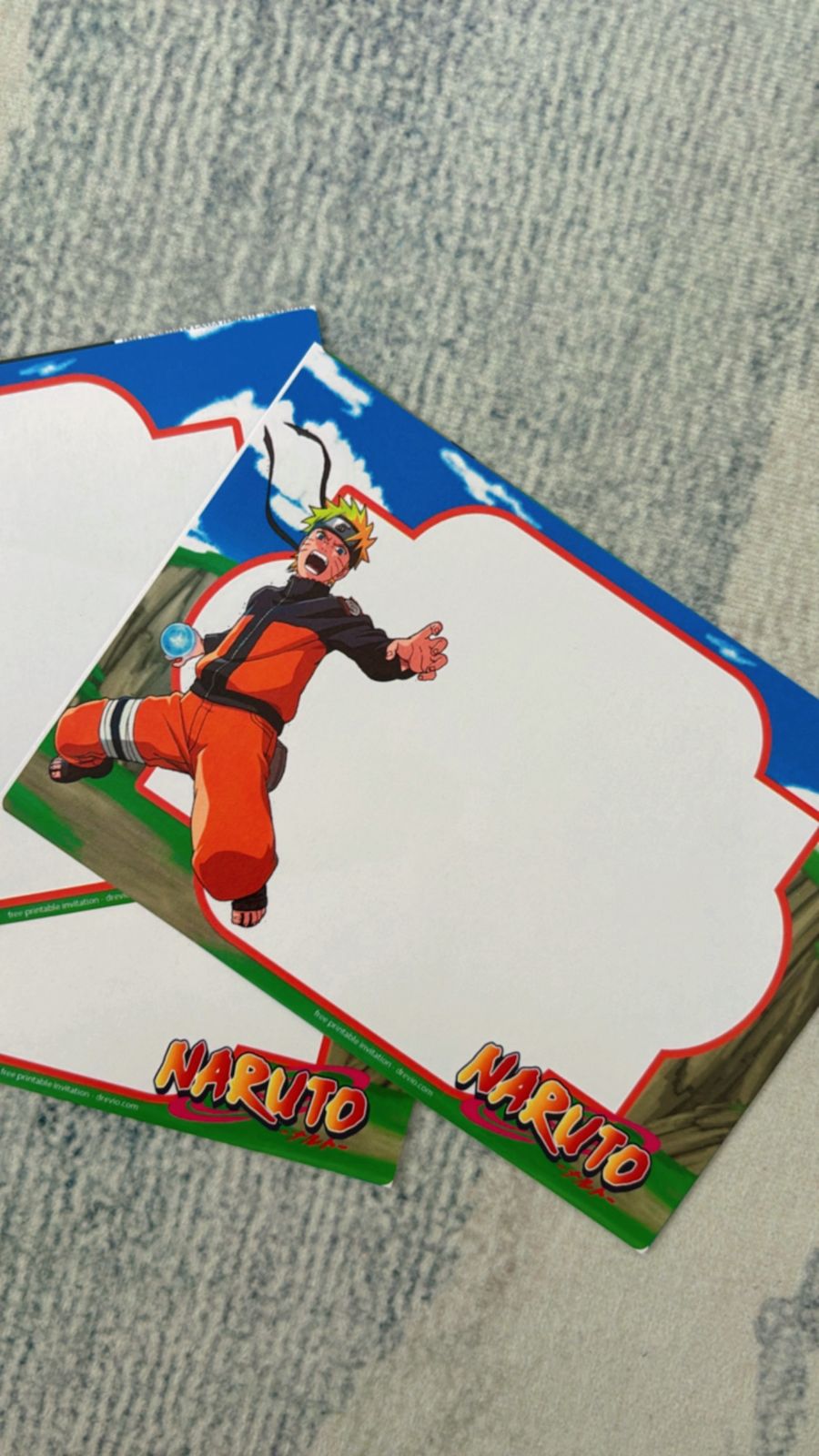 Close-up of Naruto birthday invitations featuring ninja stars, headband icons, and action-style text layout