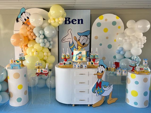 Pastel Donald Duck invitation decorated with soft clouds, stars, duck footprints, balloons and gentle Disney-themed details