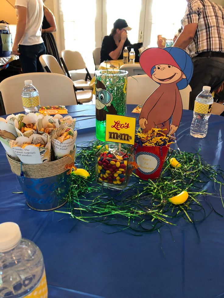Printable Curious George invitation featuring monkey, safari leaves, and party hats