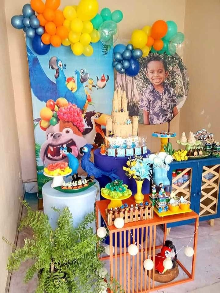 Editable Rio birthday invitation featuring blue macaws, rainforest foliage, tropical blooms, palm leaves, and playful jungle accents