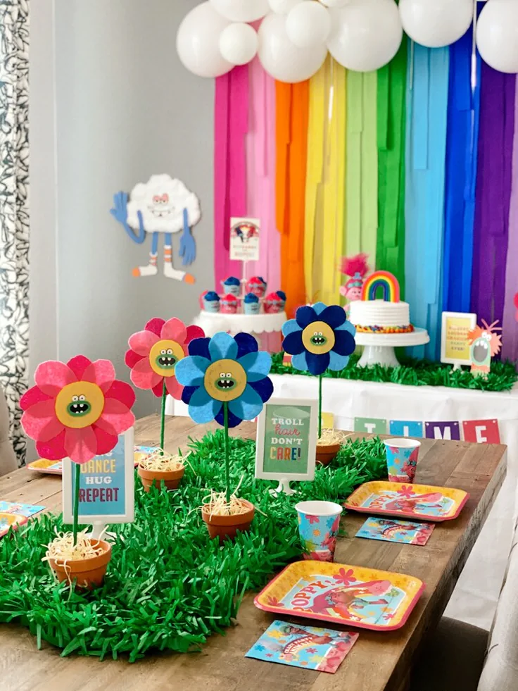 Bright Trolls birthday invitation design with pink, purple, and aqua colors, rainbow elements, music notes, and cheerful character illustrations