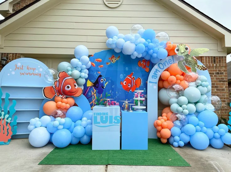 Finding Nemo invitation with colorful coral reefs, clownfish, Dory, bubbles, and ocean blue background