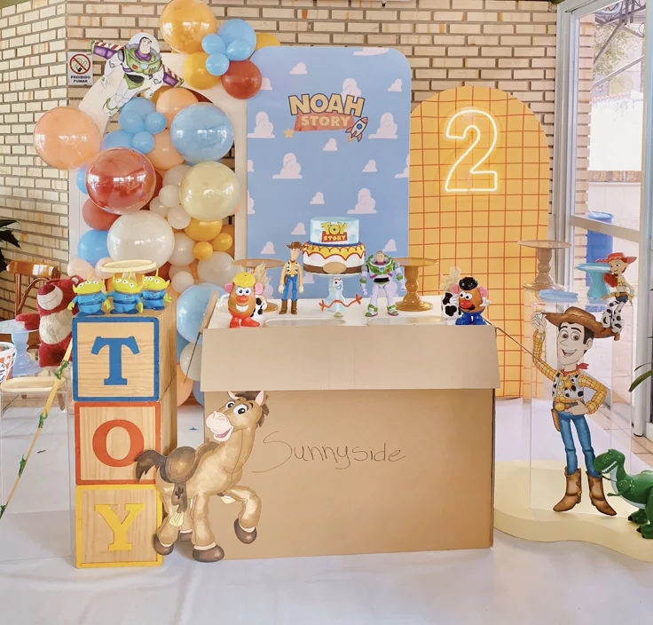 Colorful Toy Story birthday invitation featuring Buzz Lightyear, Woody, green aliens, Andy's sky, and western stars