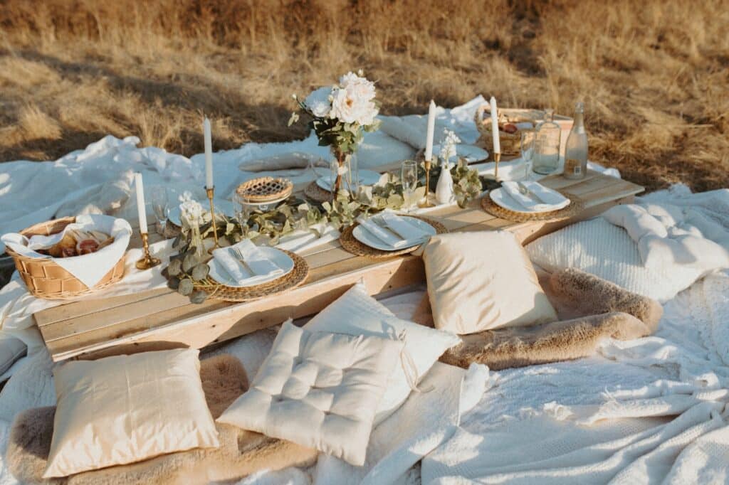 Boho Outdoor Party with pillow, burlap, wooden table, food and more