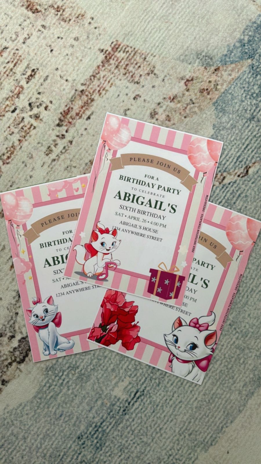 Playful Marie birthday invitation with scattered paw prints, soft pink layers, and cartoon cat illustration