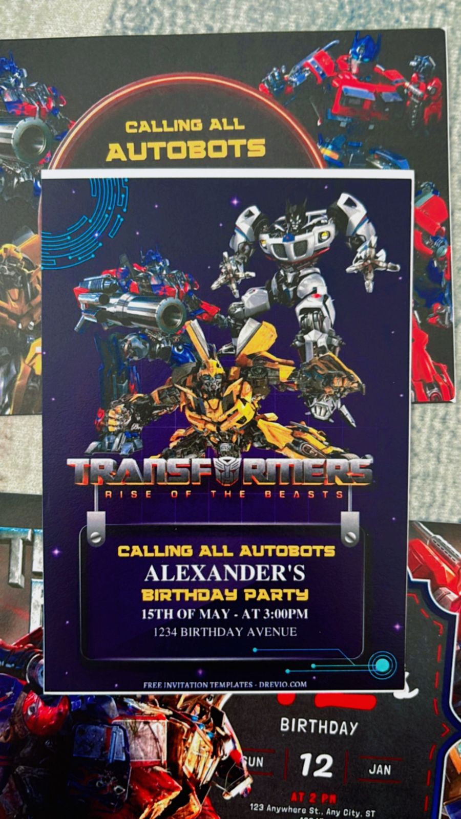 Transformer birthday invitation design with Autobot logo circled in red, metallic blue background, lightning bolt accents, and mission-style typography