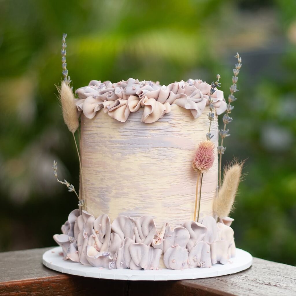 buttercream cake with delicate fresh flowers and soft gold accents