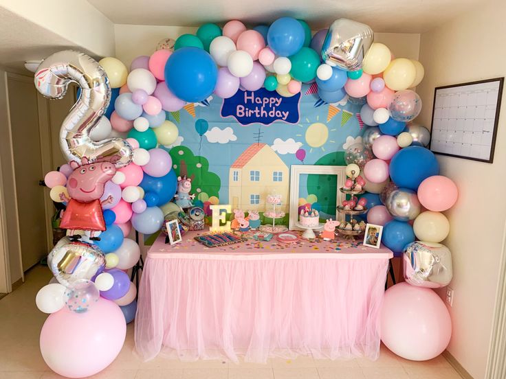Peppa Pig birthday dessert table with balloon arch
