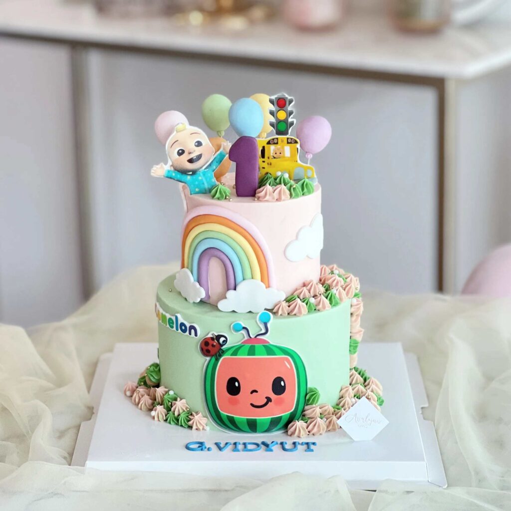 Two tier Cocomelon Birthday cake with white icing and fondant rainbow