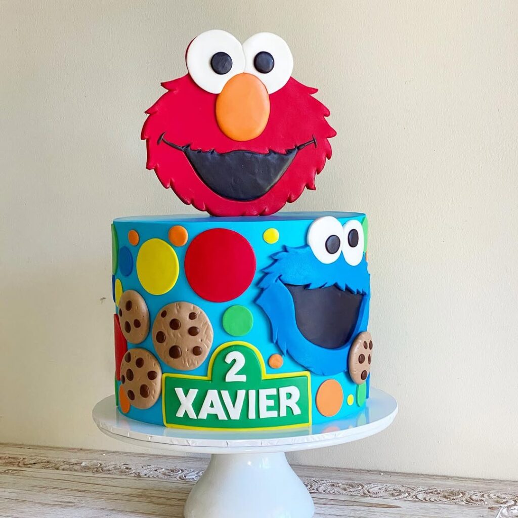 Colorful Sesame Street birthday cake with edible fondant Elmo and Cookie Monster Cake toppers