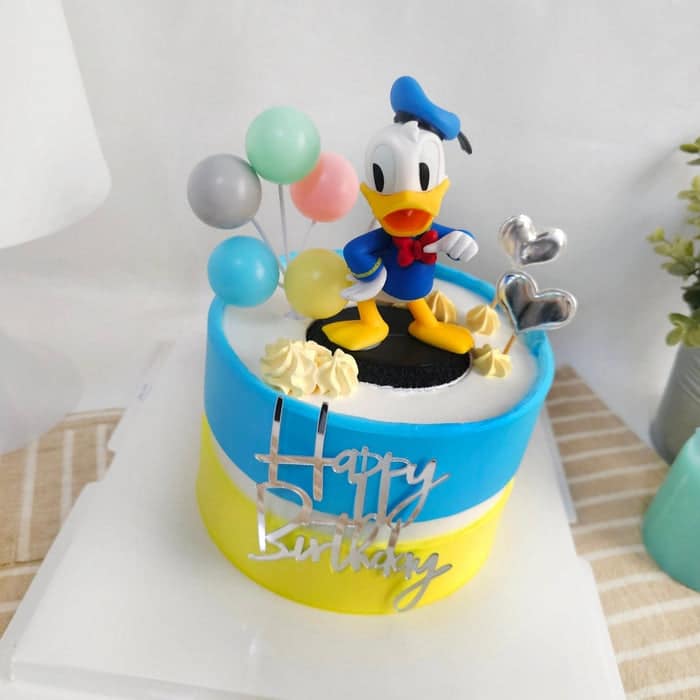 Adorable Two Tone Blue and Yellow Donald Duck Birthday Cake with adorable Donald Duck figurine as cake topper