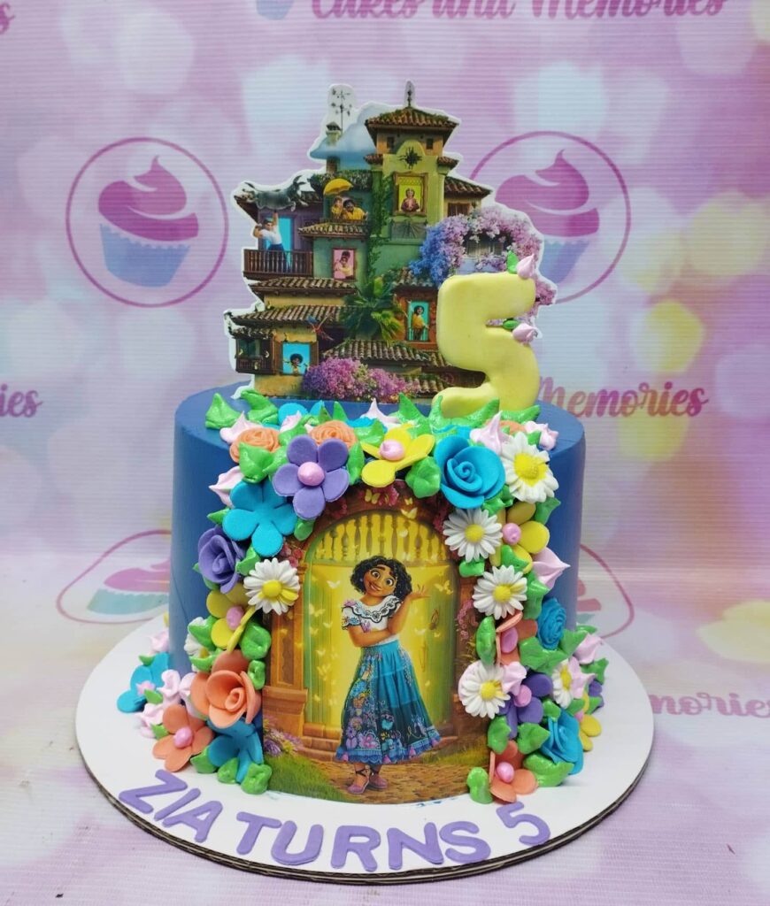 Disney Encanto Fiesta Birthday Cake with colorful flower icing and edible Mirabel Madrigal's house topper