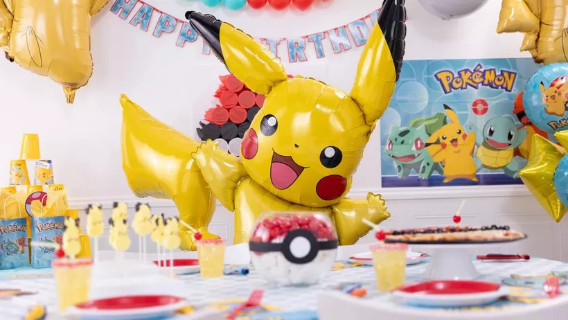 This party setup is a whole vibe, ready to make any kid's birthday lit. The aesthetic is boujee with a giant Pikachu balloon serving main character energy. The table is set with themed cups, plates, and a mid-no-more candy dish shaped like a Poké Ball. It's giving "best mom ever" energy, no cap, ensuring the celebration is anything but basic.