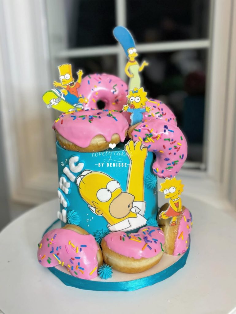 This cake is a vibrant blue masterpiece, featuring Homer Simpson himself, probably dreaming of donuts.