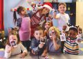 Preschool teacher taking instant print transfer to decorate a Christmas Tree, Quebec, Canada