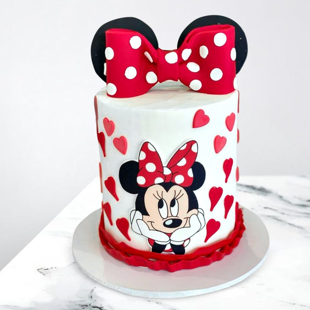 Adorable Minnie Mouse Cake with pink fondant, pink bow and cute Minnie Mouse topper